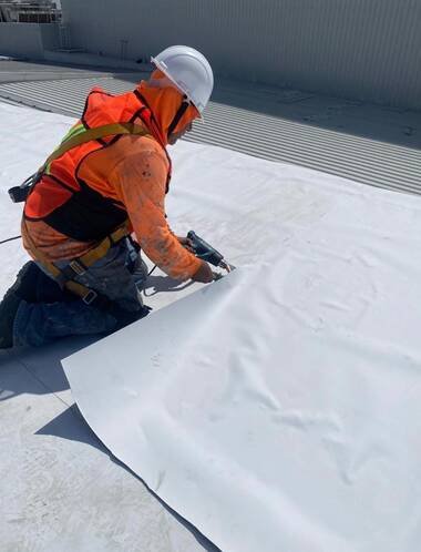 Técnico de JONAMI instalando una membrana impermeabilizante en una azotea