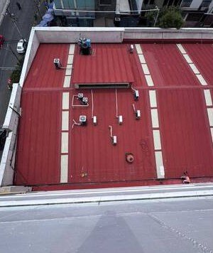 Azotea comercial con impermeabilizante rojo recién aplicado